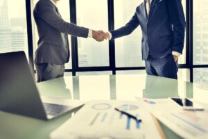 Aperto de mão entre empresários no fecho de um processo de M&A sell-side