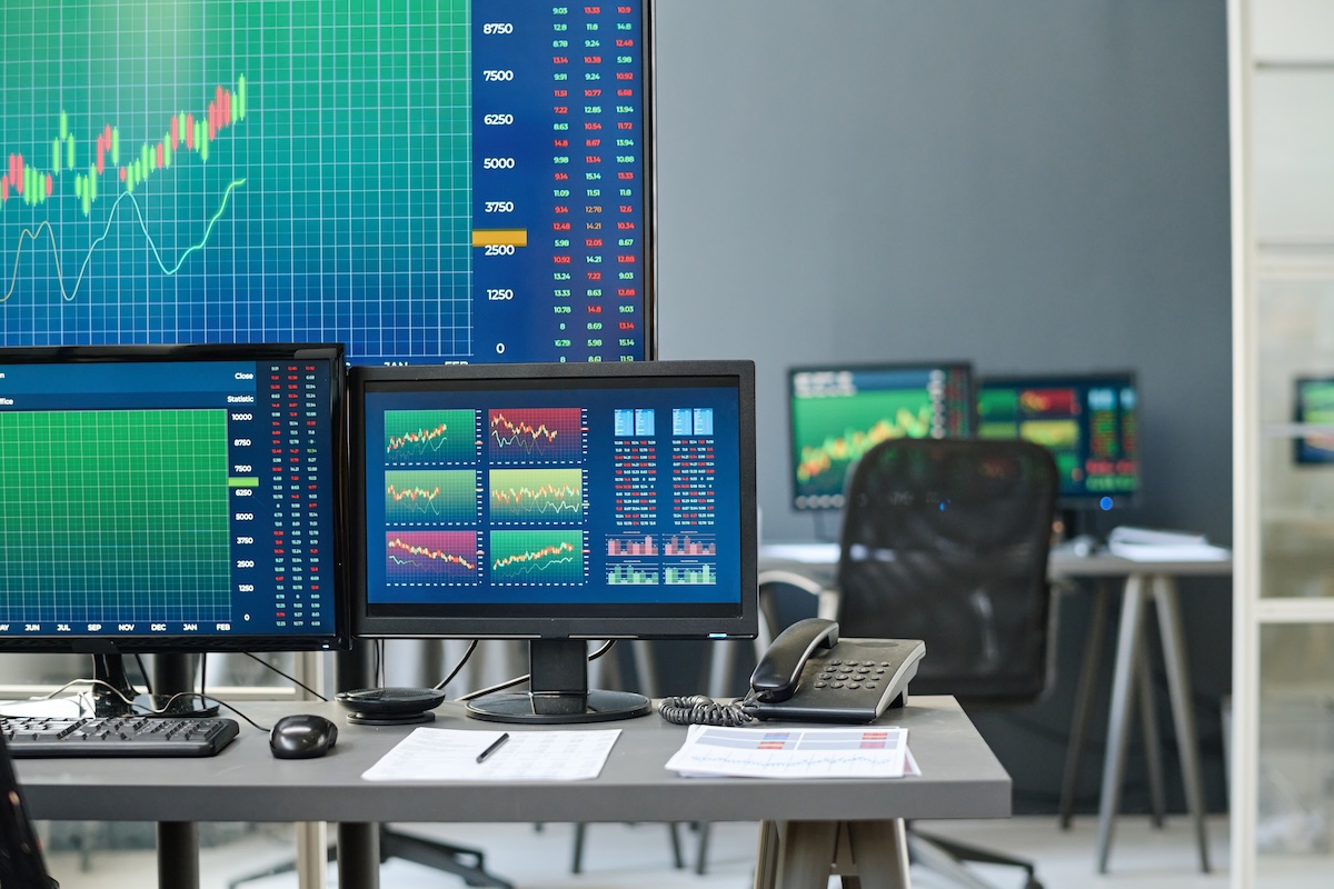 Monitores com gráficos de análise financeira num escritório, a ilustrar a avaliação de PME por search funds